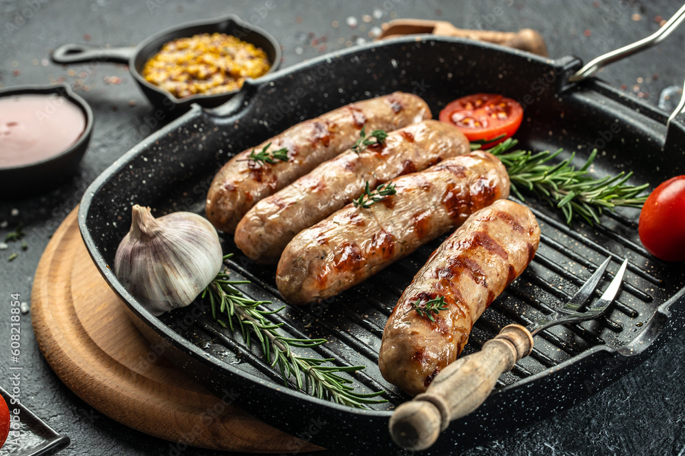 Sausages with spices in a pan with rosemary herbs on the grill pan. banner, menu, recipe place for text, top view