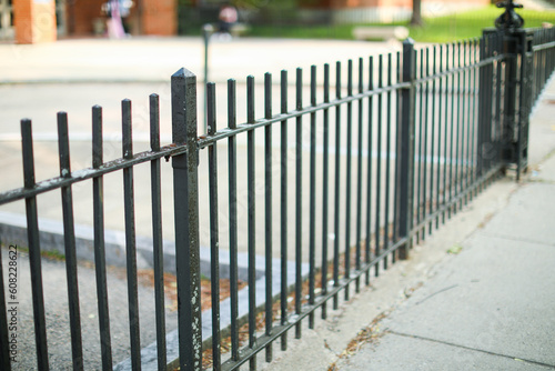 Metal fence symbolizes boundaries, security, protection, privacy, and delineates spaces with its strong and sturdy presence
