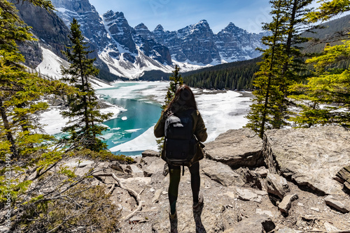Woman tourist backpacker viewing the beautiful landscape of banff national park. Icy mountains. Tourist hiking.