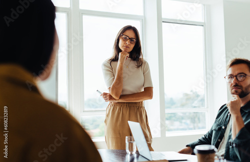 Obraz na plátně Business woman listening to a discussion in a team meeting