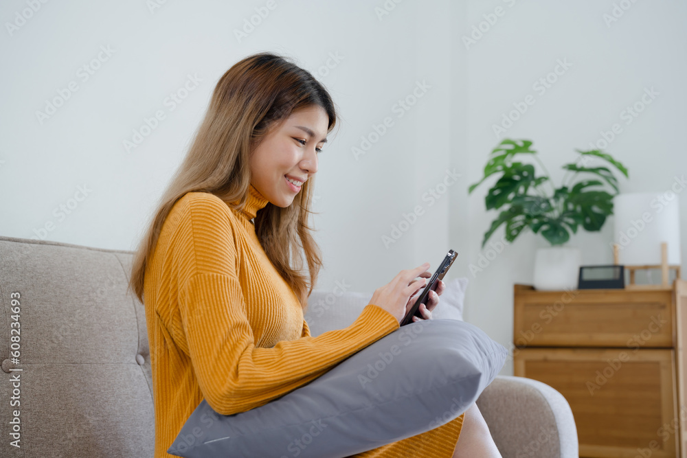 Asian girl using cell phone for checking social media at home holding smartphone in morning Asian girl using cell phone for checking social media at home holding smartphone in morning