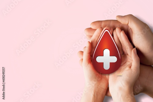 Hands holding red blood drop, donor day concept