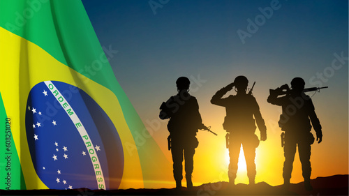 Silhouette of a soldiers against the sunset with Brazil flag. Armed Forces of Brazil concept. EPS10 vector