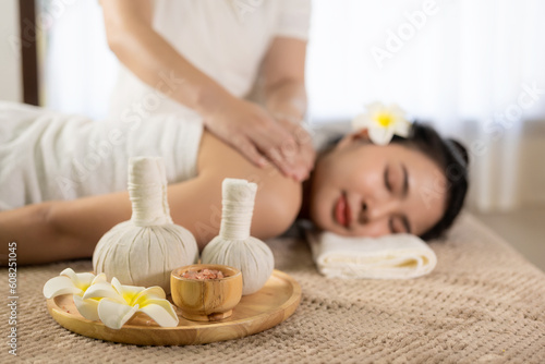 Beautiful young Asian woman getting massage in spa environment, traditional aromatherapy and beauty therapy, close-up photo.