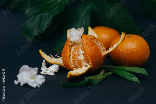 Orange tangerines with flowers close-up with copy space on a dark background photo