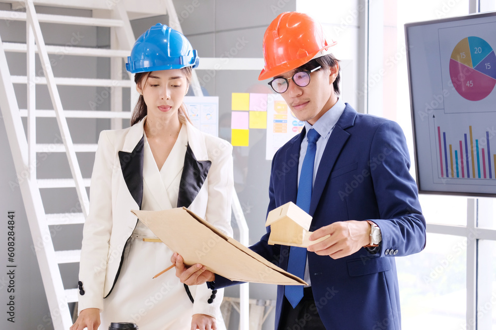 Engineer looks at the drawings to design the house structure. Engineer looks at the drawings to design the house structure.