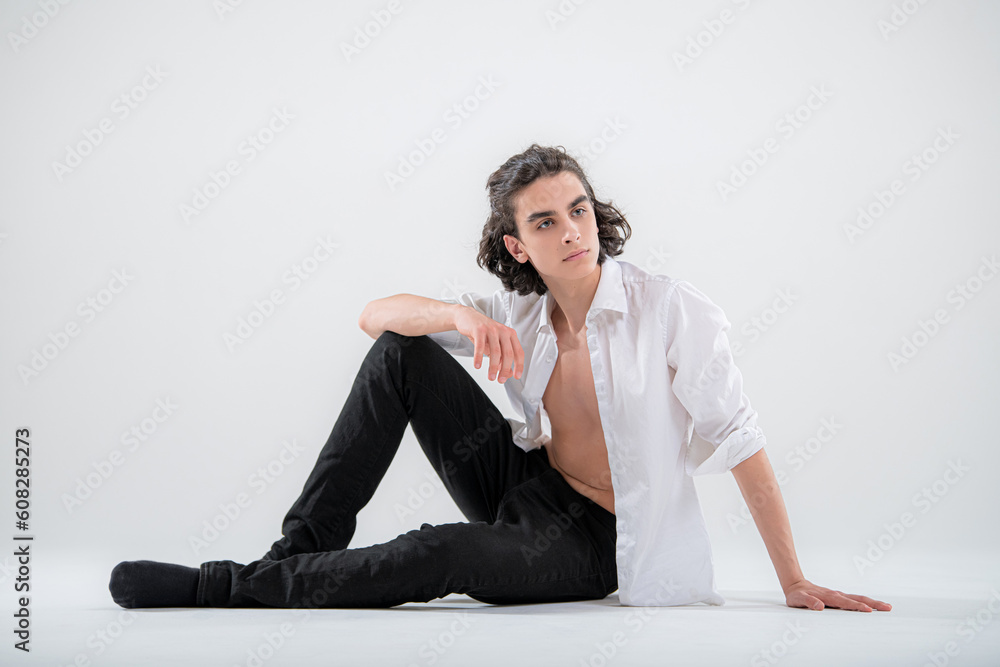 Full-length portrait of a standing handsome young man model in a white shirt and jeans on a white background. Full-length portrait of a standing handsome young man model in a white shirt and jeans on a white background.