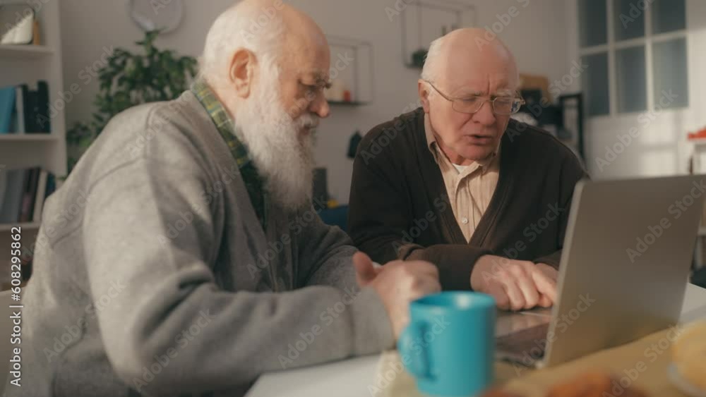 Elderly male friends figuring out how to use laptop, modern technology problems Elderly male friends figuring out how to use laptop, modern technology problems