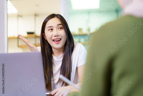 Happy beautiful diverse Asian women working and discussing together in the pantry area in co-working space, female students using laptop - notebook computer. Asian women colleague having a discussion.