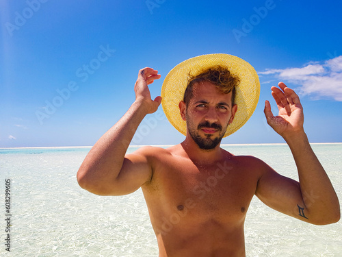 boy protruding his straw hat to avoid the sun's rays