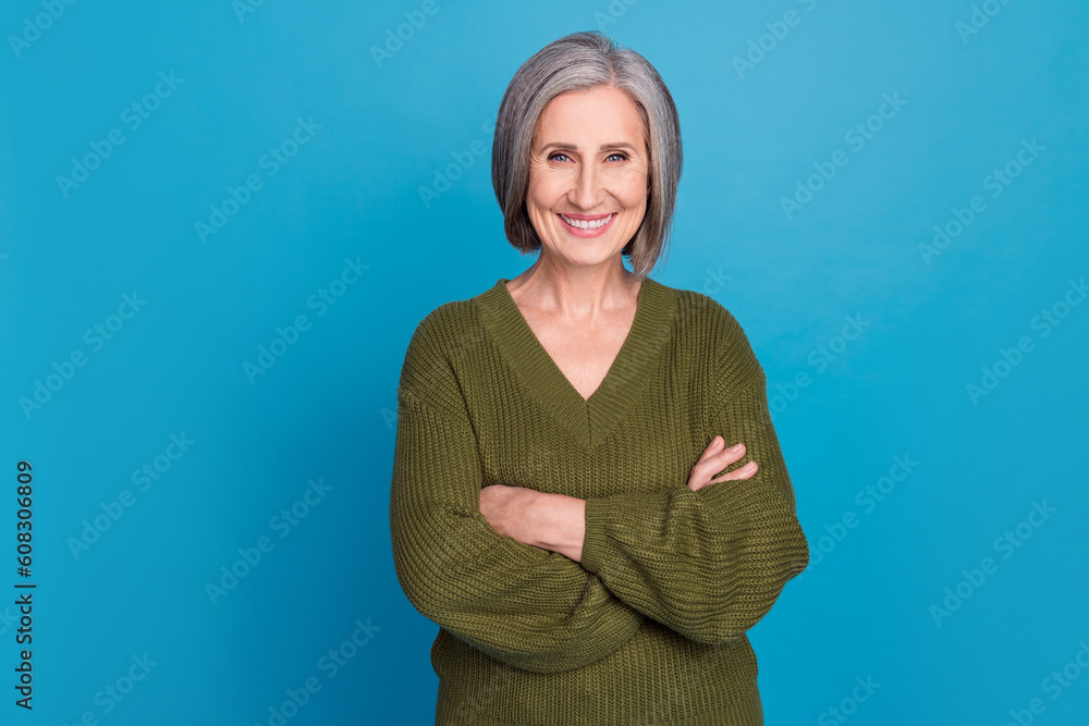 Fototapeta premium Photo of friendly positive nice woman with bob hairstyle dressed khaki sweater smiling arms crossed isolated on blue color background