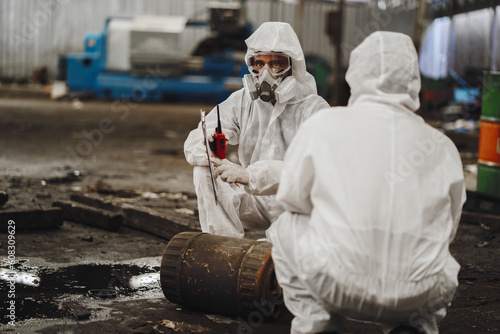 chemical specialist wear safety uniform and gas mask inspecting chemical leak in industry factory