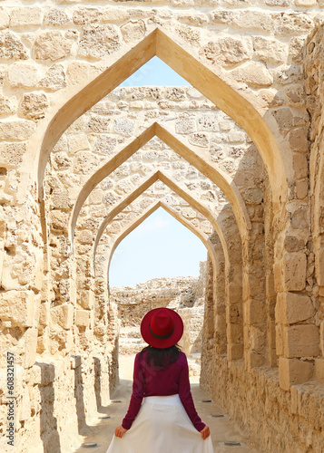 Female Visitor Walking Along the Iconic Archways of Qal'at al-Bahrain Or the Portuguese Fort in Manama, Bahrain photo
