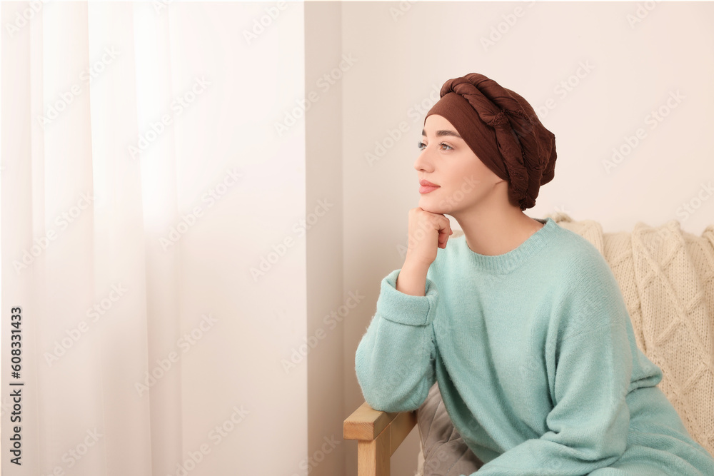 Cancer patient. Young woman with headscarf near window indoors, space for text Cancer patient. Young woman with headscarf near window indoors, space for text
