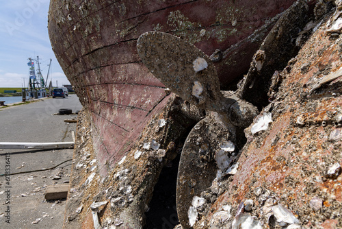 propeller of an old boat at the end of life with decay and mussles on it