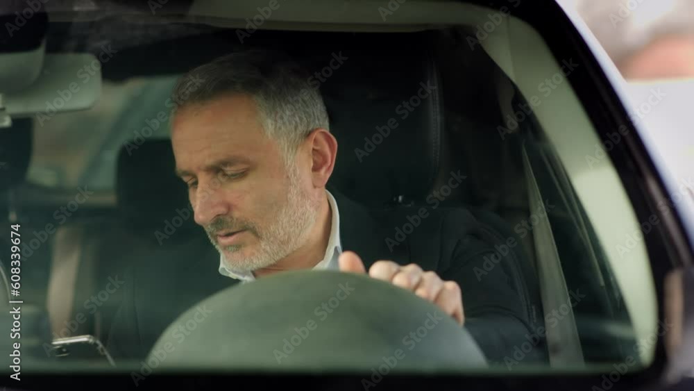 Frontal shot of a gray-haired man with a phone in his hand who gets into the car. A man in a strict business suit gets into the car and prepares to go to a meeting with business partners. Frontal shot of a gray-haired man with a phone in his hand who gets into the car. A man in a strict business suit gets into the car and prepares to go to a meeting with business partners.