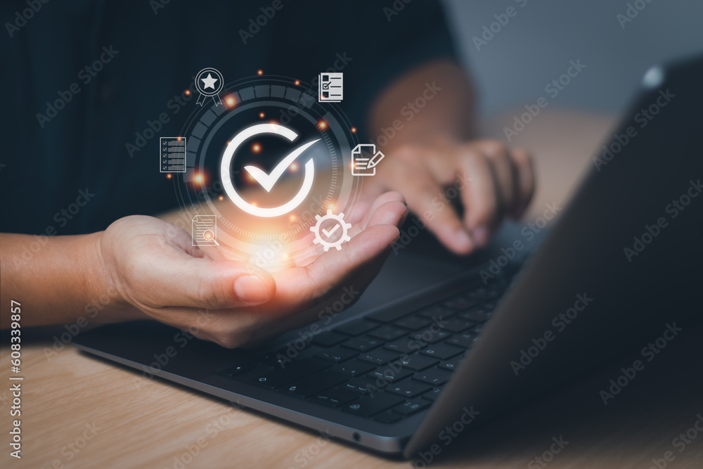 Businessman hand showing checked icon, concept Quality Assurance(QA) and Quality Control (QC) certification standards in a product or service guarantee Businessman hand showing checked icon, concept Quality Assurance(QA) and Quality Control (QC) certification standards in a product or service guarantee