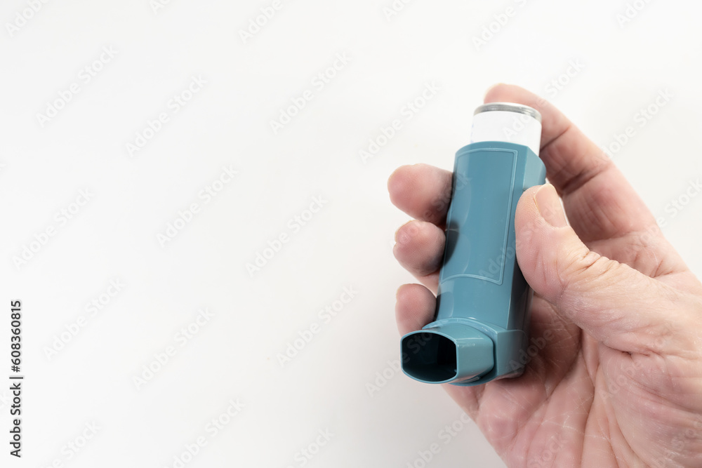 Hand holding a blue inhaler, also known as pump or allergy spray, medical  device for asthma or COPD patients, light background, large copy space,  selected focus Stock Photo | Adobe Stock