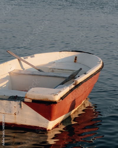 A white and orange colored boat in the sea at sunset photo