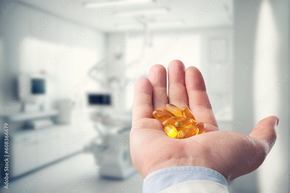 Obraz premium Dietary supplement concept, young hand hold pills