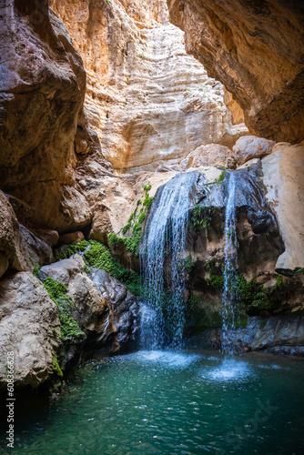 waterfall in huge canyon with azure lake