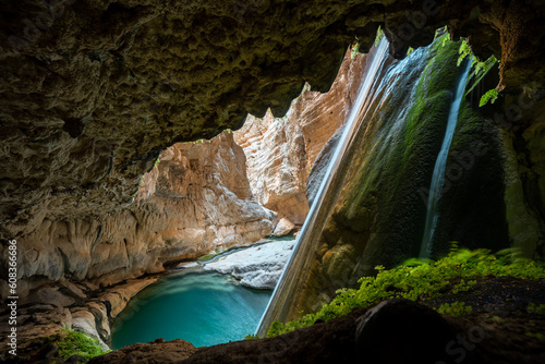 Fototapeta Naklejka Na Ścianę i Meble -  waterfall in huge canyon with azure lake from a cave