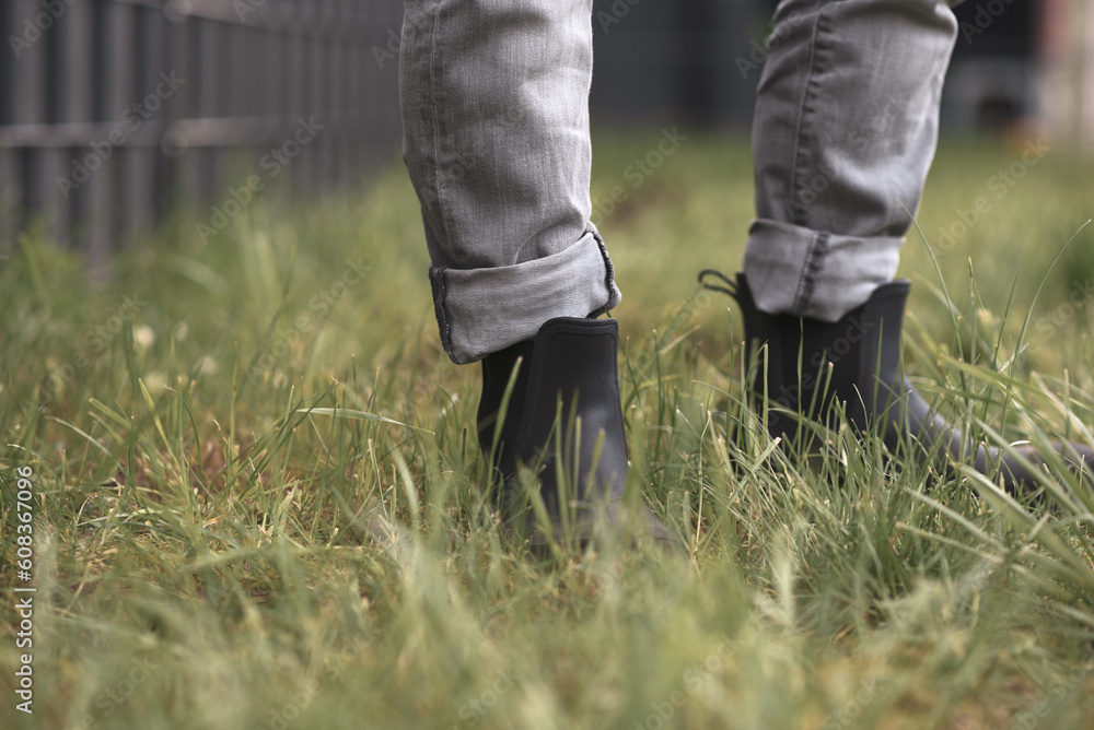 legs of a person in short rubber boots in the grass legs of a person in short rubber boots in the grass