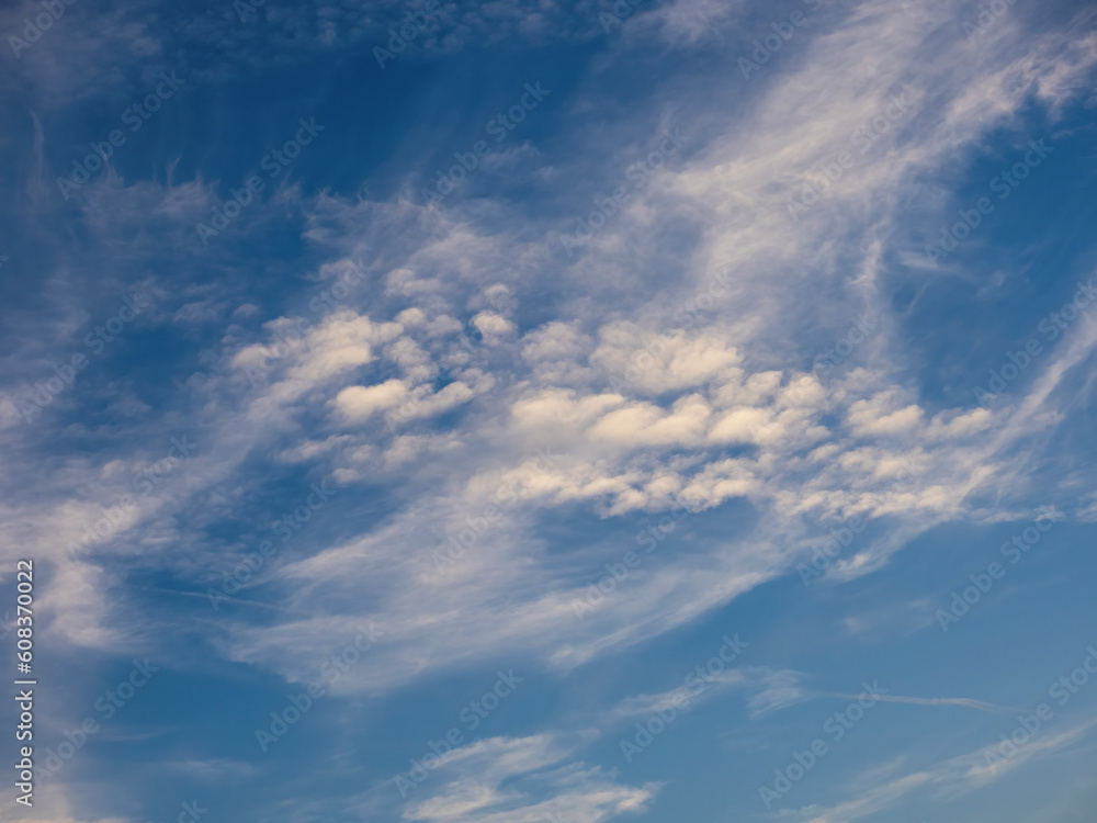 Blue sky with unusual abstract white clouds. Strange dramatic clouds pattern texture.