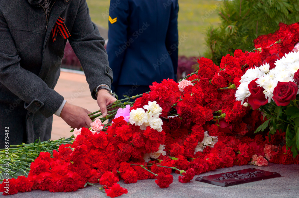 Nazi Flower Laying flowers at the monument. An elderly man places carnations at the ...