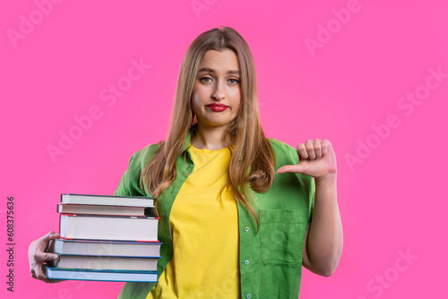 Lazy schoolgirl or student is dissatisfied with amount of books homework on pink