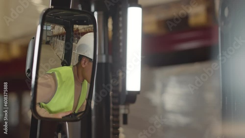 Wallpaper Mural Through rear view forklift mirror shot of young Biracial female operator wearing safety hard hat and acid green vest giving instructions to employees while working together at warehouse Torontodigital.ca
