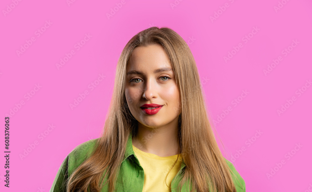 Fototapeta premium Pretty blonde woman portrait on pink studio background. Colorful outfit. Smiling