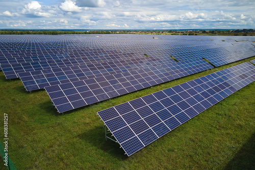 Foto Aerial view of large sustainable electrical power plant with rows of solar photovoltaic panels for producing clean electric energy
