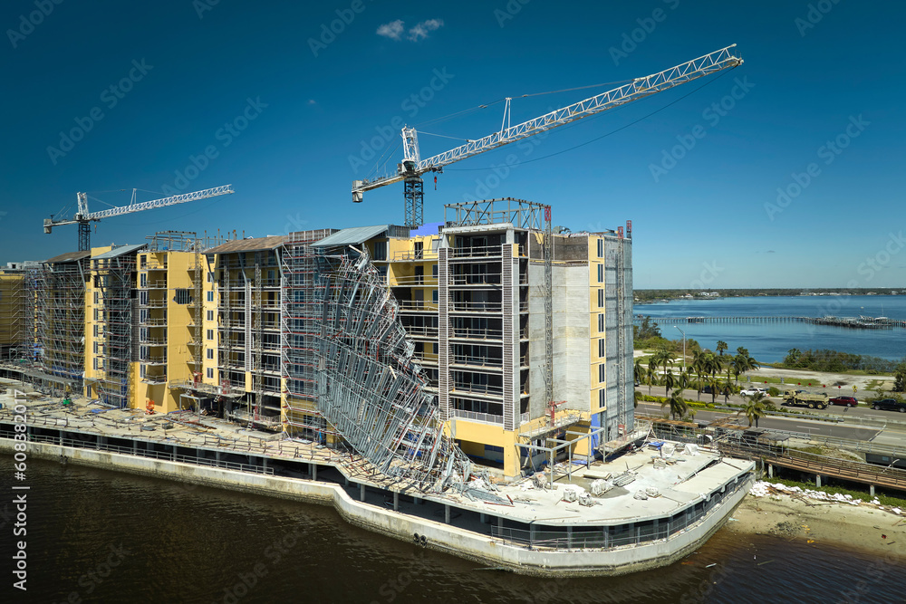 Aerial view of ruined by hurricane Ian construction scaffolding on high apartment building site in Port Charlotte, USA