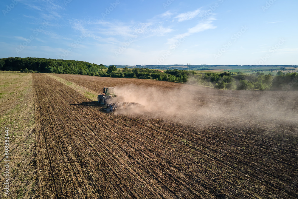 Aerial view of tractor plowing agriculural farm field preparing soil for seeding in summer Aerial view of tractor plowing agriculural farm field preparing soil for seeding in summer