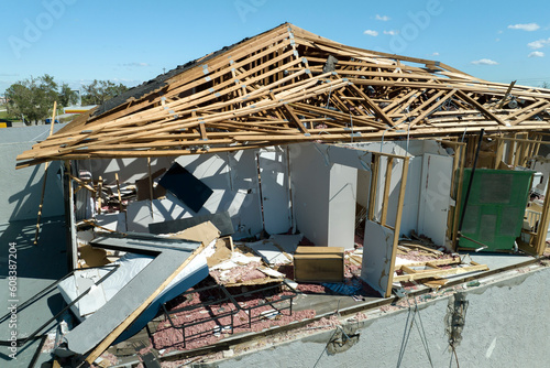 Hurricane Ian destroyed house roof and walls in Florida residential area. Natural disaster and its consequences