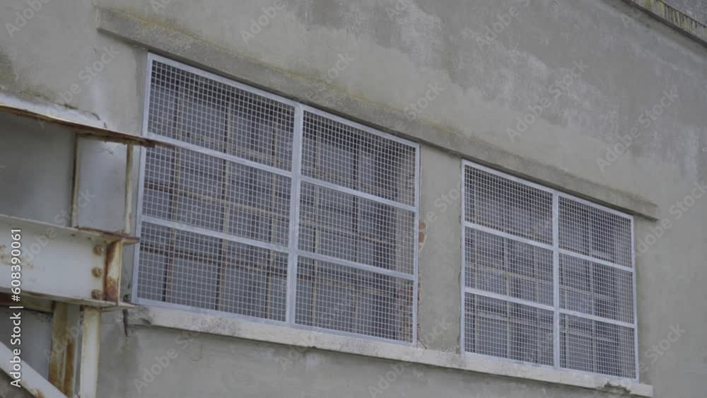 Windows of a factory closes by wire mesh Windows of a factory closes by wire mesh