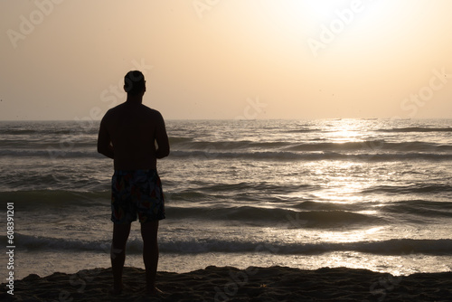 A person watching a sunset at sea.