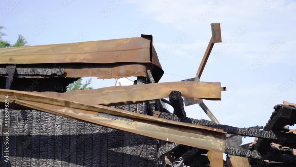 Burnt and destroyed building with a metal roof Burnt and destroyed building with a metal roof