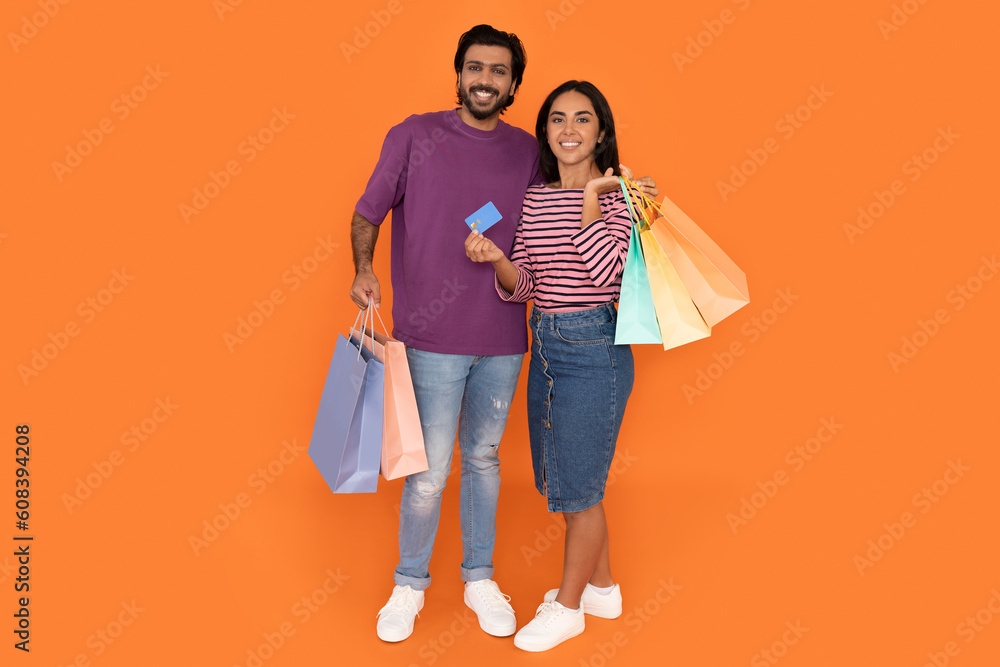 Happy indian lovers holding shopping bags and bank card Happy indian lovers holding shopping bags and bank card