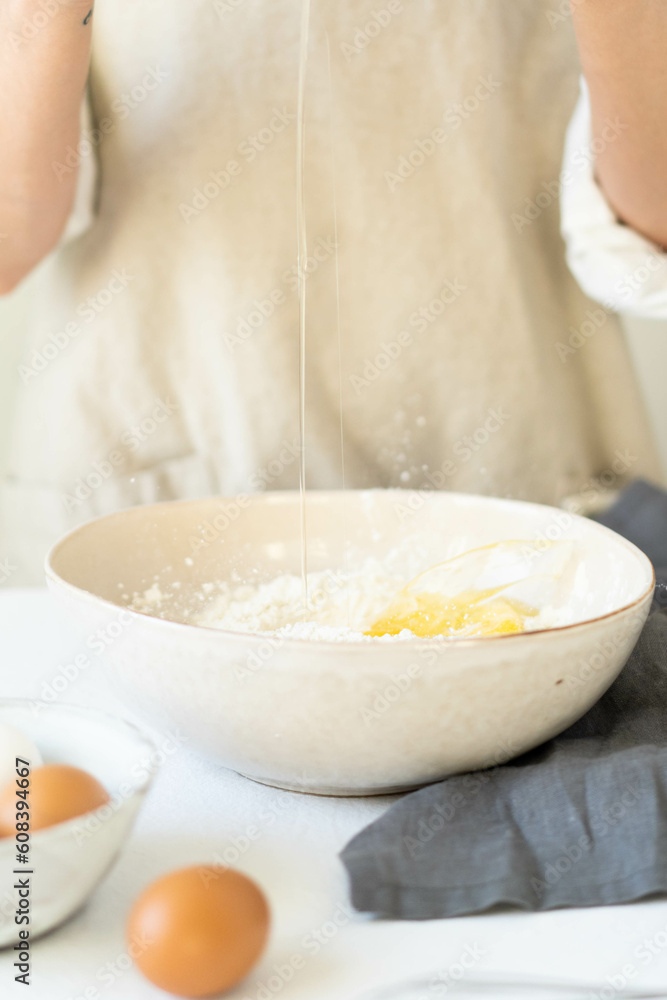 Cooking eggs with women's hands in a bowl of flour. Making a delicious breakfast. Cooking eggs with women's hands in a bowl of flour. Making a delicious breakfast.