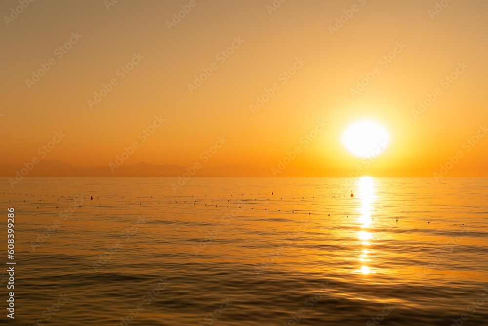 Dawn over Antalya, View from the coast of Beldibi, Türkiye. Summer morning on the sea coast in orange shades, wallpaper.