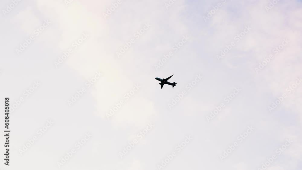 Silhouette of a passenger plane in the sky against the background of clouds and sunset Silhouette of a passenger plane in the sky against the background of clouds and sunset