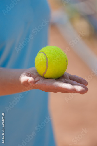 person holds tennis ball in his hands.tennis court made of red clay soil with markings for game or competition. sports and recreation, professional performance champions in lawn tennis with rackets © MyJuly