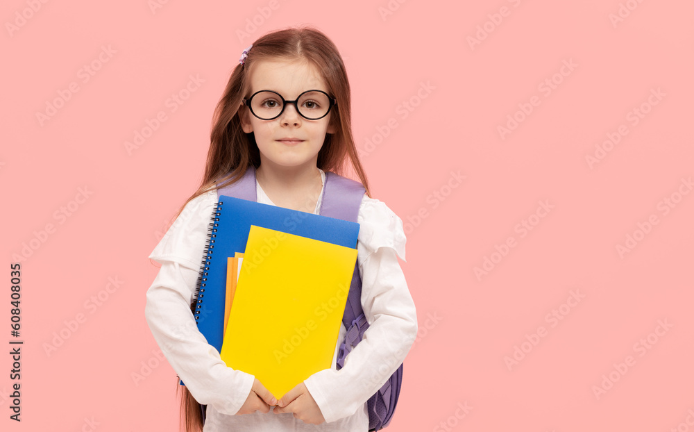 Portrait of a schoolgirl with textbooks and a backpack on a pink background. Back to school Portrait of a schoolgirl with textbooks and a backpack on a pink background. Back to school