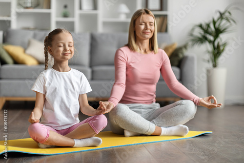 Family Yoga. Mother And Little Daughter Meditating Together At Home