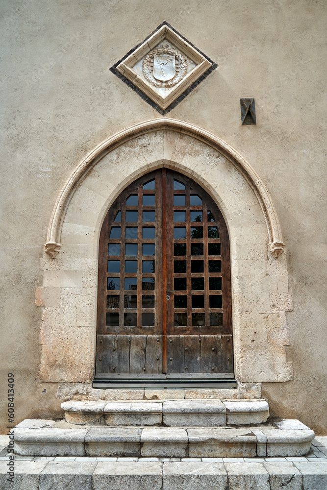 Old wooden door to a historic building in the city of Taormina
