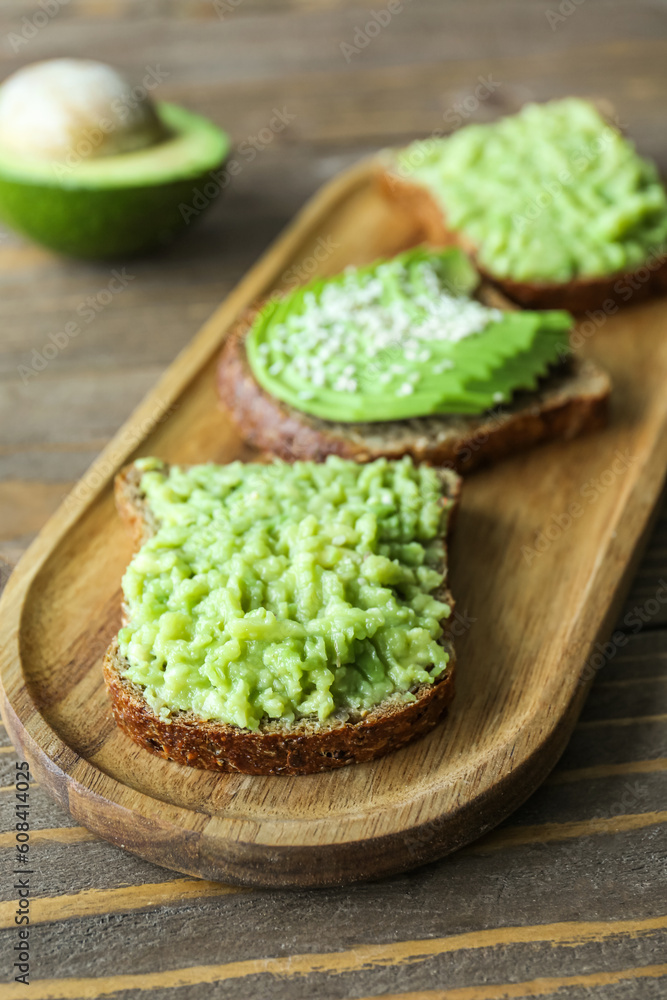 Board of tasty avocado toasts on wooden background Board of tasty avocado toasts on wooden background