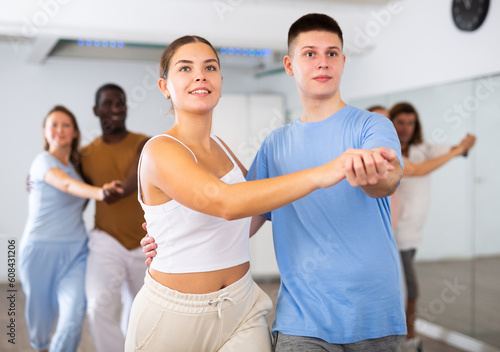 Young woman and teen boy dancing pair dance in dance hall