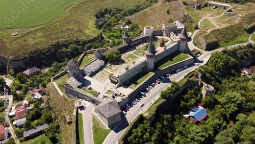 Aerial view of Kamianets-Podilsky historic fortress castle and canyon of the Smotrych River, Novoplanivskyi Bridge in Ukraine. Medieval castle with impenetrable walls, towers and battlements photo